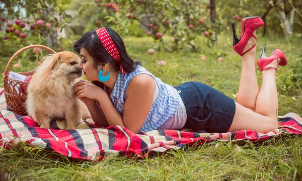外でピクニックをしている若い女性 秋の時間だ ヴィンテージレトロなピンアップスタイルとかなり日 人間とペットの概念 — ストック写真