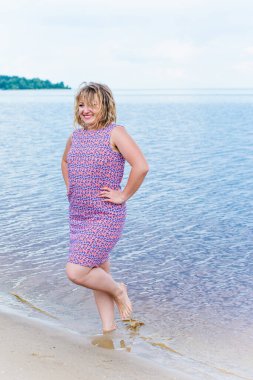 Genç, mutlu, gülümseyen, güzel, normal elbiseli, doğal görünüşlü, profesyonel makyajlı ve saç stili olan bir kadın.