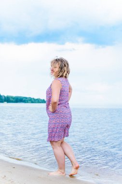 Genç, mutlu, gülümseyen, güzel, normal elbiseli, doğal görünüşlü, profesyonel makyajlı ve saç stili olan bir kadın.