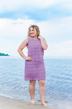 Genç, mutlu, gülümseyen, güzel, normal elbiseli, doğal görünüşlü, profesyonel makyajlı ve saç stili olan bir kadın.