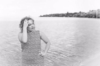 Genç, mutlu, gülümseyen, güzel, normal elbiseli, doğal görünüşlü, profesyonel makyajlı ve saç stili olan bir kadın.