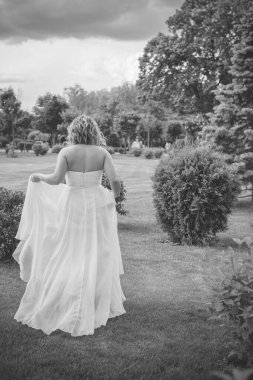 Parkta romantik şefkat gelini. Genç bayan yaz bahçesinde eğleniyor. Düğün gününde poz veren güzel bir gelin, gelinlikli güzel bir kız. 