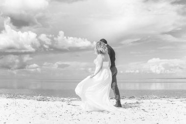 Düğünde sarışın gelin ve damat. Mutlu evlilik çifti. Güzel gelin, beyaz elbiseli genç bayan damadı öpüyor ve yaz günü dışarıda eğleniyor. Yeni evlenmiş, genç bir aile..