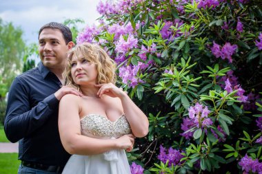 Düğünde sarışın gelin ve damat. Mutlu evlilik çifti. Güzel gelin, beyaz elbiseli genç bayan damadı öpüyor ve yaz günü dışarıda eğleniyor. Yeni evlenmiş, genç bir aile..