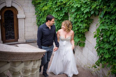 Düğünde sarışın gelin ve damat. Mutlu evlilik çifti. Güzel gelin, beyaz elbiseli genç bayan damadı öpüyor ve yaz günü dışarıda eğleniyor. Yeni evlenmiş, genç bir aile..