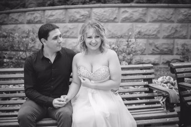 Düğünde sarışın gelin ve damat. Mutlu evlilik çifti. Güzel gelin, beyaz elbiseli genç bayan damadı öpüyor ve yaz günü dışarıda eğleniyor. Yeni evlenmiş, genç bir aile..