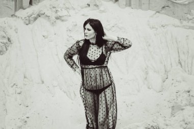 Puantiyeli ve iç çamaşırlı seksi, uzun siyah şeffaf elbiseli kadın. 