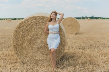 Doğuştan modern, dolgun kalçalı, beyaz kostümlü güzel bir kadın. Kadınlık kavramı