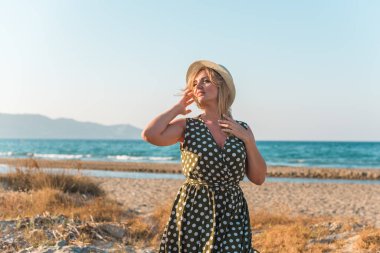 Tatillerde güzel bir kadın, plaj manzaralı bir yer, sahil, deniz. Tatiller ve macera konsepti