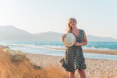 Tatillerde güzel bir kadın, plaj manzaralı bir yer, sahil, deniz. Tatiller ve macera konsepti