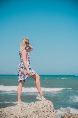 Tatillerde güzel bir kadın, plaj manzaralı bir yer, sahil, deniz. Tatiller ve macera konsepti