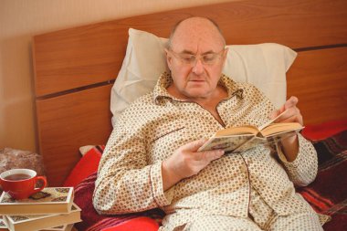 Evde yatakta yatan son sınıf öğrencisi için endişelendim. Yatakta yatan olgun bir adam pijama giyer, acı hisseder, hastalanır..