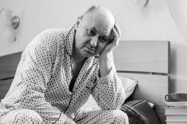 Evde yatakta yatan son sınıf öğrencisi için endişelendim. Yatakta yatan olgun bir adam pijama giyer, acı hisseder, hastalanır..