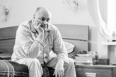 Evde yatakta yatan son sınıf öğrencisi için endişelendim. Yatakta yatan olgun bir adam pijama giyer, acı hisseder, hastalanır..