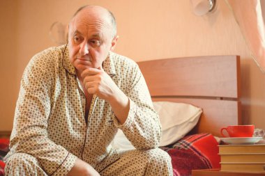 Evde yatakta yatan son sınıf öğrencisi için endişelendim. Yatakta yatan olgun bir adam pijama giyer, acı hisseder, hastalanır..