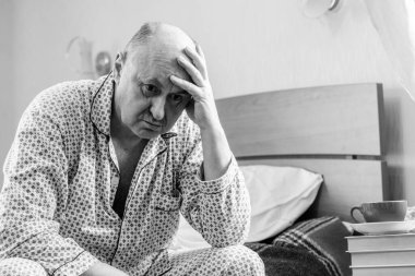 Evde yatakta yatan son sınıf öğrencisi için endişelendim. Yatakta yatan olgun bir adam pijama giyer, acı hisseder, hastalanır..