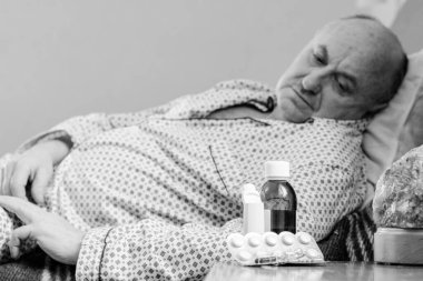 Evde yatakta yatan son sınıf öğrencisi için endişelendim. Yatakta yatan olgun bir adam pijama giyer, acı hisseder, hastalanır..