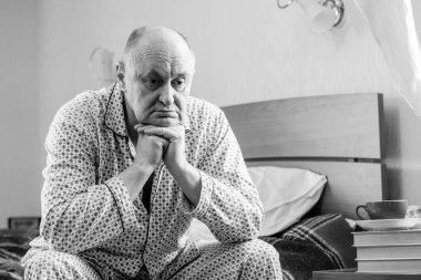 Evde yatakta yatan son sınıf öğrencisi için endişelendim. Yatakta yatan olgun bir adam pijama giyer, acı hisseder, hastalanır..