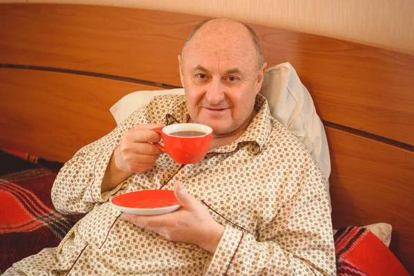 Senior man wake up in the morning in a good mood dressed in pajamas, retired people lifestyle