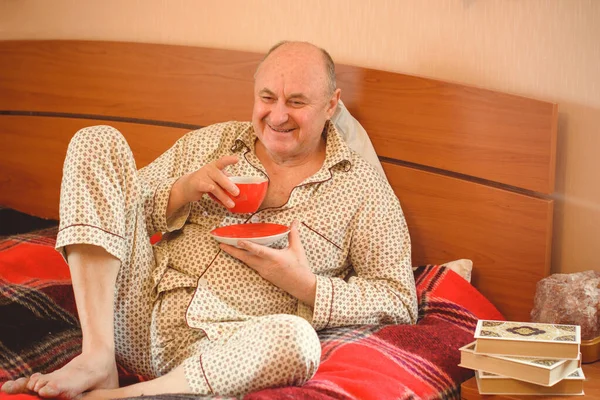 Senior man wake up in the morning in a good mood dressed in pajamas, retired people lifestyle