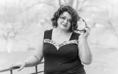 Orta yaşlı ve hayattan zevk alan iri yarı bir kadın. Aşırı kilolu, şık giyinmiş olgun bir bayan. Doğal güzellik.