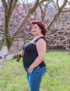 Orta yaşlı ve hayattan zevk alan iri yarı bir kadın. Aşırı kilolu, şık giyinmiş olgun bir bayan. Doğal güzellik.