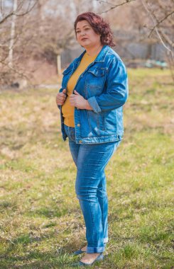 Orta yaşlı ve hayattan zevk alan iri yarı bir kadın. Aşırı kilolu, şık giyinmiş olgun bir bayan. Doğal güzellik.