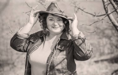 Orta yaşlı ve hayattan zevk alan iri yarı bir kadın. Aşırı kilolu, şık giyinmiş olgun bir bayan. Doğal güzellik.