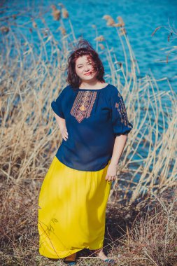 Orta yaşlı ve hayattan zevk alan iri yarı bir kadın. Aşırı kilolu, şık giyinmiş olgun bir bayan. Doğal güzellik.