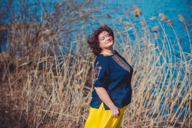 Orta yaşlı ve hayattan zevk alan iri yarı bir kadın. Aşırı kilolu, şık giyinmiş olgun bir bayan. Doğal güzellik.