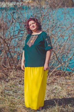 Orta yaşlı ve hayattan zevk alan iri yarı bir kadın. Aşırı kilolu, şık giyinmiş olgun bir bayan. Doğal güzellik.