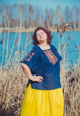 Orta yaşlı ve hayattan zevk alan iri yarı bir kadın. Aşırı kilolu, şık giyinmiş olgun bir bayan. Doğal güzellik.