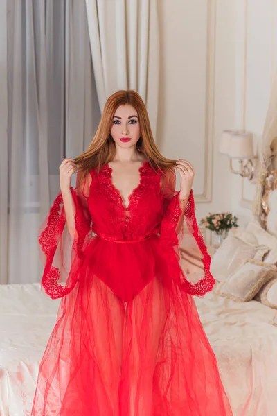 Tutkulu Kızıl Saçlı Kadın Yatak Odasında Kırmızı Havadar Bir Elbise — Stok fotoğraf