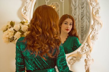 Viktorya dönemi tarzında görkemli bir kadın, kadife yeşili, uzun zümrüt köpüklü bir elbise giyiyor. Kadınlık ve çekicilik kavramı