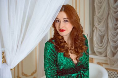 Viktorya dönemi tarzında görkemli bir kadın, kadife yeşili, uzun zümrüt köpüklü bir elbise giyiyor. Kadınlık ve çekicilik kavramı