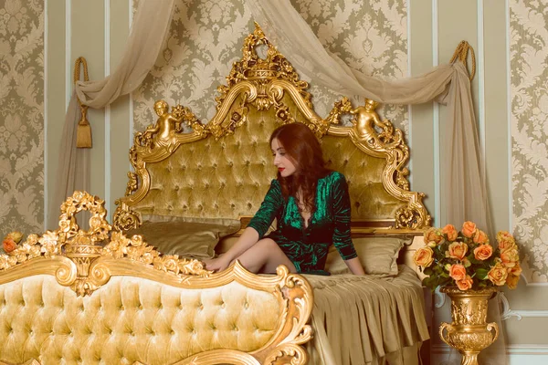 ビクトリア様式のインテリアの豪華な女性は ベルベットの緑の長いエメラルドの泡のガウンを着ています 女性らしさと魅力の概念 — ストック写真