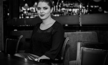 Sıcak atmosfer restoranında genç, zarif, iri yarı bir kadın. Bayan randevuyu romantik bir havada bekler. Kalın vintage tonlarda portre