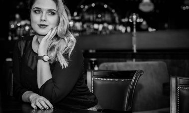 Sıcak atmosfer restoranında genç, zarif, iri yarı bir kadın. Bayan randevuyu romantik bir havada bekler. Kalın vintage tonlarda portre