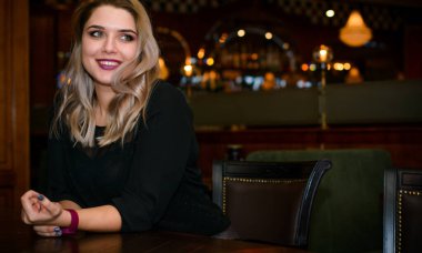 Sıcak atmosfer restoranında genç, zarif, iri yarı bir kadın. Bayan randevuyu romantik bir havada bekler. Kalın vintage tonlarda portre