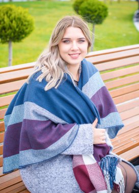 Sarı saçlı, cüsseli, sevimli, basit bir kadın. Alışverişte yürüyor, vitrinlere bakıyor. Alışveriş ve şık aksesuarlar gibi şeyleri seçiyor.