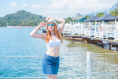   Kadın dinleniyor ve denizde eğleniyor. Tatilde iyi bir ruh hali, sıcak hava ve mutlu bir turist.