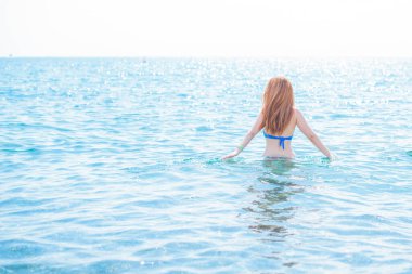   Kadın dinleniyor ve denizde eğleniyor. Tatilde iyi bir ruh hali, sıcak hava ve mutlu bir turist.