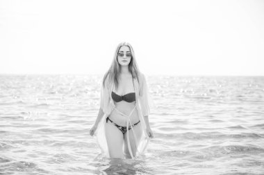   Kadın dinleniyor ve denizde eğleniyor. Tatilde iyi bir ruh hali, sıcak hava ve mutlu bir turist.