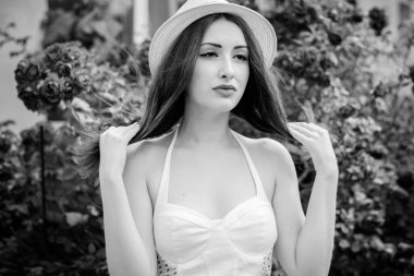 Tarlada açık tenli, güzel kızıl saçlı bir bakire, klasik modaya uygun giyinir. Bir kız çiçeklerin ve otların yanında dinleniyor güzelliğin tadını çıkarıyor.