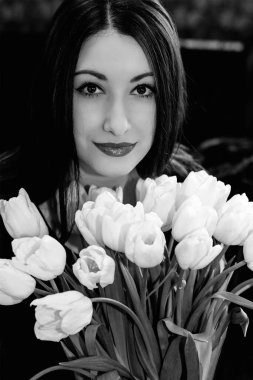 Güzel bir kadın, akşam buluşması, kaliteli makyaj ve buket beyaz lalelerle.