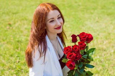  Açık havada çiçek buketi olan mutlu bir kadın. İyi ruh hali ve kadın yaşam tarzı konsepti