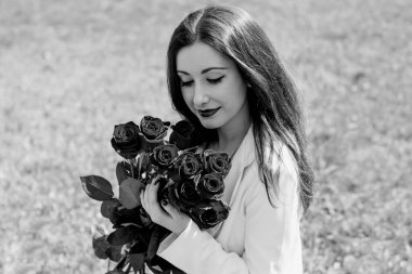  Açık havada çiçek buketi olan mutlu bir kadın. İyi ruh hali ve kadın yaşam tarzı konsepti