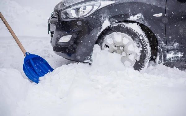 Winter, people and car problem concept. Man try on pushing the car, stuck in the snow. Mutual aid. Winter problem. transportation, winter and vehicle concept - closeup of man pushing car stuck in snow