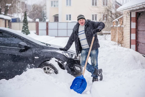 Winter, people and car problem concept. Man try on pushing the car, stuck in the snow. Mutual aid. Winter problem. transportation, winter and vehicle concept - closeup of man pushing car stuck in snow