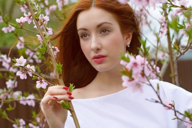 Bahar çiçekleri bahçesinde romantik bir kadın. Kadın kavramı ve şefkat, modern güzellik veya kadınlık.